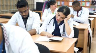 Doctors sitting at desks studying and reading.